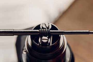 Specialist replaces spring for smoking vape.Professional maintaining electronic cigarette in...