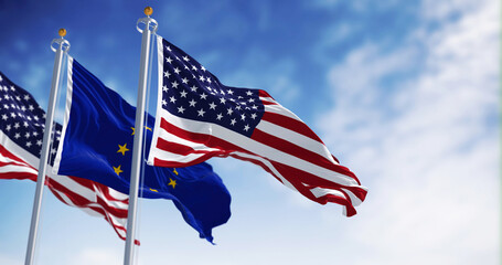 The flags of the United States of America and the European Union waving in the wind on a clear day