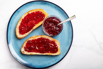 Obraz premium Open Sandwich with toasted sourdough white bread slices and raspberry jam