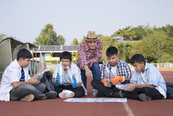 group of private volunteer looking at the map to divide the waste collection zones in public stadium,concept adult develop volunteering spirit among teenagers to help society