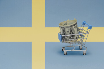 Metal shopping basket with dollar money banknote on the national flag of sweden background. consumer basket concept. 3d illustration