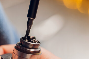 Specialist replaces spring for smoking vape.Professional maintaining electronic cigarette in...