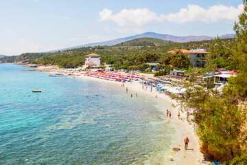 A beautiful beach in Greece with a turquoise bay and sandy shoreline, providing an idyllic paradise to relax and soak up the sun.