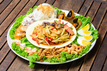 Favorite food of Thailand. Papaya spicy salad with variety side dishes served in tray.
