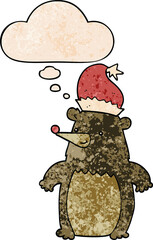 cartoon bear wearing christmas hat and thought bubble in grunge texture pattern style