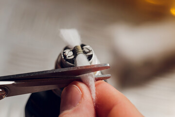 Specialist replaces spring for smoking vape.Professional maintaining electronic cigarette in...