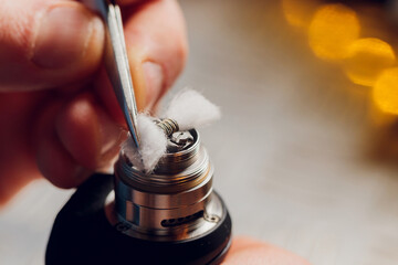 Specialist replaces spring for smoking vape.Professional maintaining electronic cigarette in...