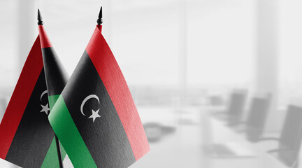 Small flags of the Libya on an abstract blurry background - obrazy, fototapety, plakaty
