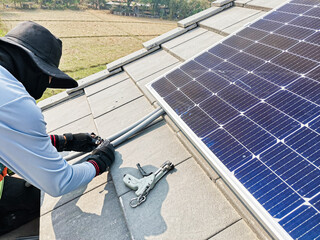 A technician is installing solar panels on the roof to use solar energy to power the building.