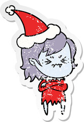 annoyed distressed sticker cartoon of a vampire girl wearing santa hat
