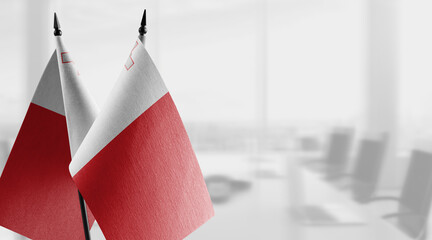 Small flags of the Malta on an abstract blurry background