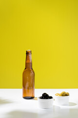 Botella de cerveza fría con aceitunas