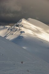 Winter alpine landscape, huge amount of blown snow, danger of snow avalanche. Winter adventure and...