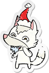 distressed sticker cartoon of a hungry wolf wearing santa hat