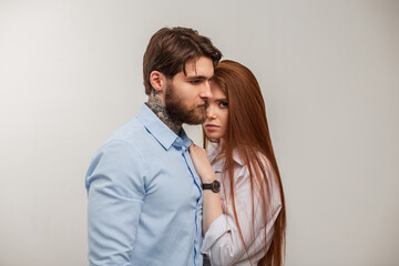 Elegant trendy stylish couple in the studio. Handsome brutal hipster man with beard and tattoos and...