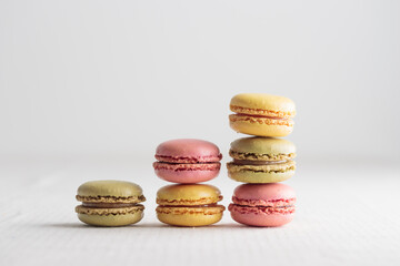 Colorful macaroons on white background, increase in profits of the confectionery production