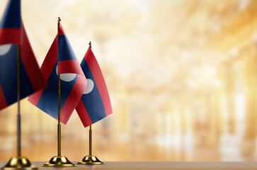Small flags of the Laos on an abstract blurry background