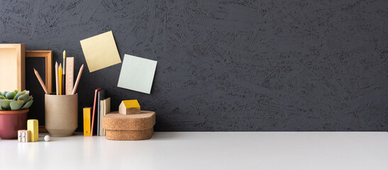 Office table, empty desk with simple office things and white wall copy space. Creative workspace.