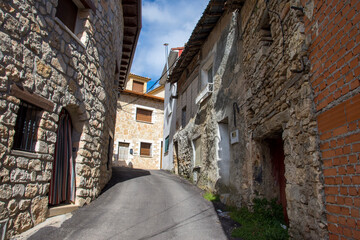 A view of a rustic street in a village with walls made of rocks