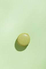 Green pistacio colored macaroon on green background. Gift for 8 March, International Women's Day, Valentine Day