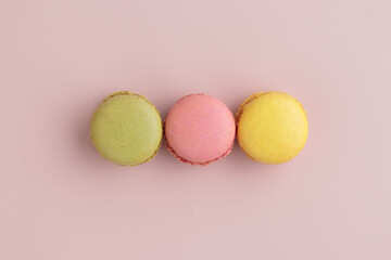 Three pastel colored macaroons on pink background, colorful french cookies pattern. Gift for 8 March, International Women's Day, Valentine Day