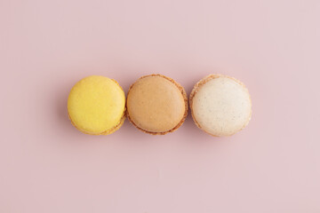 Three pastel colored macaroons on pink background, colorful french cookies pattern. Gift for 8 March, International Women's Day, Valentine Day