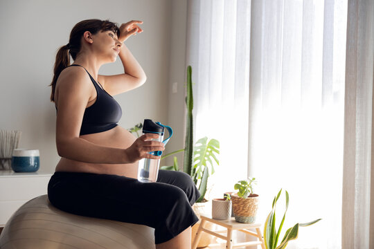 Pegnant woman drinking water after exercise