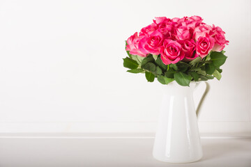 Obraz premium Beautiful bunch of fresh pink roses in full bloom against white background. Bouquet of flowers. Copy space for text. Valentine's day or Mother's day card.