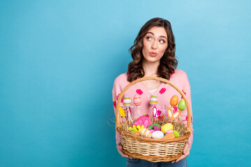Photo of adorable dreamy woman wear pink cardigan looking empty space rising easter sweets basket...