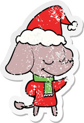 distressed sticker cartoon of a smiling elephant wearing scarf wearing santa hat