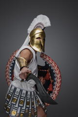Portrait of attacking soldier from antique greece dressed in white tunic and armor.