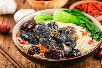 A bowl of black chicken noodles