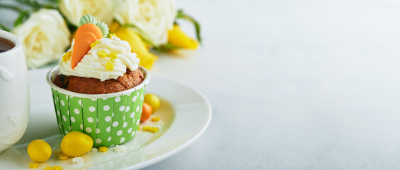 Carrot cake cupcakes for Easter. Carrot cupcakes with cream cheese frosting decorated with tiny marzipan carrots on white background. Happy Easter and spring holiday concept. Holydays homemade