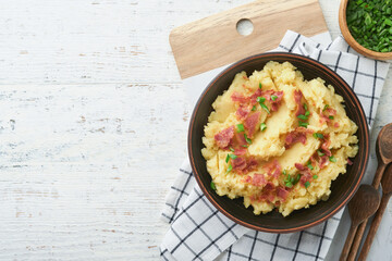 Mashed potatoes. Bacon mashed potatoes with green onion, pepper and cheddar cheese in bowl on old wooden backgrounds. Delicious creamy mashed potatoes. Top view.