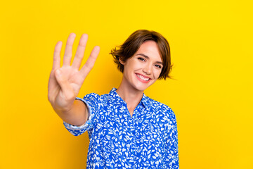 Photo portrait of pretty young girl showing four fingers count numbers dressed stylish print garment isolated on yellow color background
