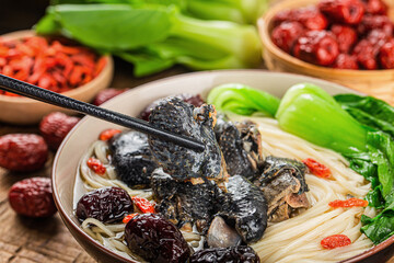 A bowl of black chicken noodles