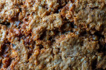 Crust on oat cookies as an abstract background or texture, closeup, top view, macro