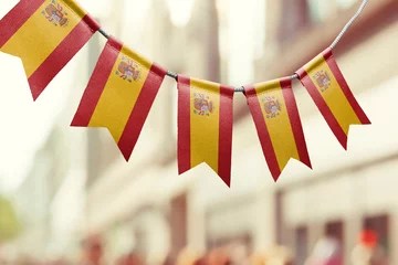 Foto auf Acrylglas A garland of Spain national flags on an abstract blurred background © butenkow