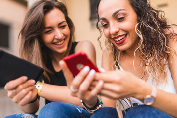 Millennials happy girls using mobile phones and laughing