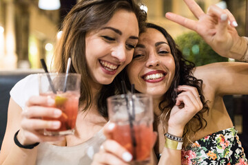 Two happy women enjoying a drink together