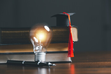 Light bulbs and books with graduation hat. Concept of reading books, knowledge, and searching for...