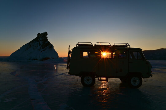 Silhouette of Vintage UAZ 452 Car and Elenka Island During Sunset Starburst at Lake Baikal