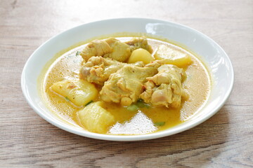 chicken drumsticks massaman curry with slice potato and onion on plate