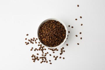 Coffee beans in the white bowl. Top view. Isolated on white background.