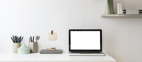 Office table, empty screen with simple office things and white wall copy space. Creative workspace.	
