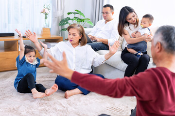 The family have fun relax engaged in fitness yoga at home using online instruction from laptop