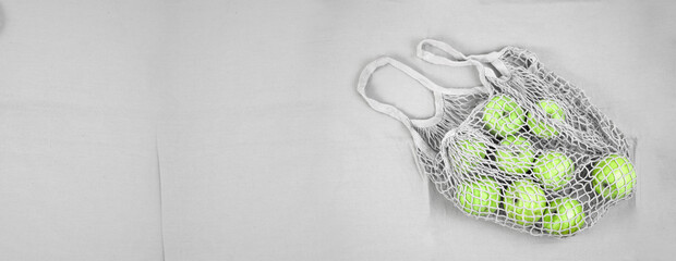 Green fresh apples in a grey grid on a grey background. Naturalness freshness concept vitamins veganism. Space for text on the left