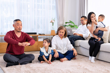 Fototapeta premium The family have fun relax engaged in fitness yoga at home using online instruction from laptop