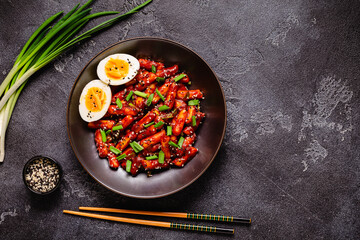 Tteokbokki, Teopokki fried rice cake in black bowl.