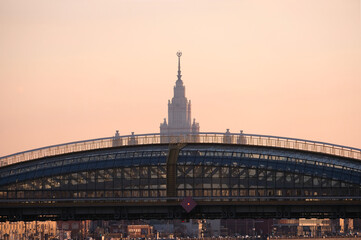 Obraz premium Contour of of Moscow Satte University building after arc bridge sunset evening view